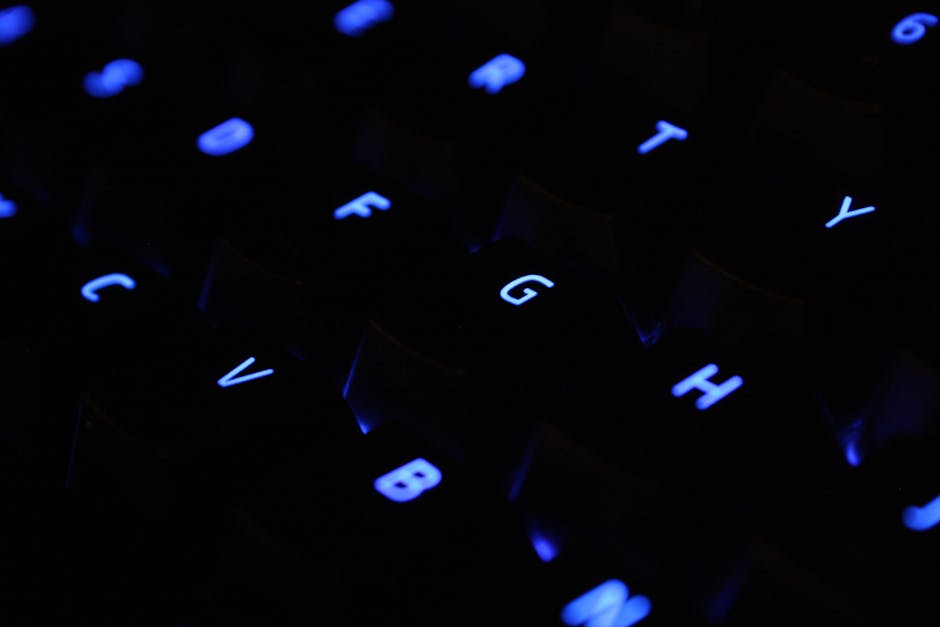 A detailed shot of blue backlit keyboard keys in a dark setting